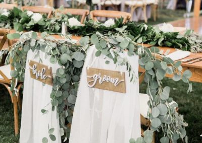 greenery on bride and groom chairs and table