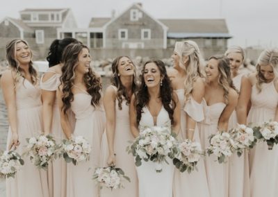Bridal party laughing with bouquets