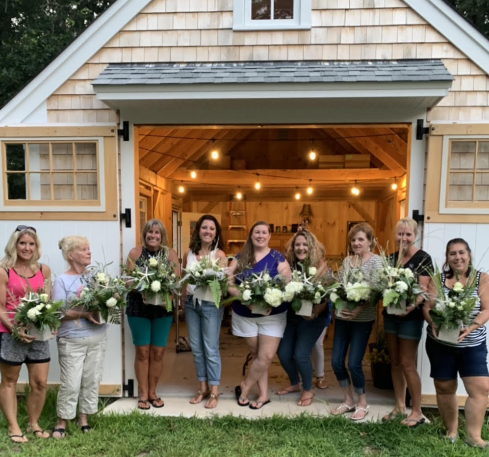 women showing arrangements after floral class